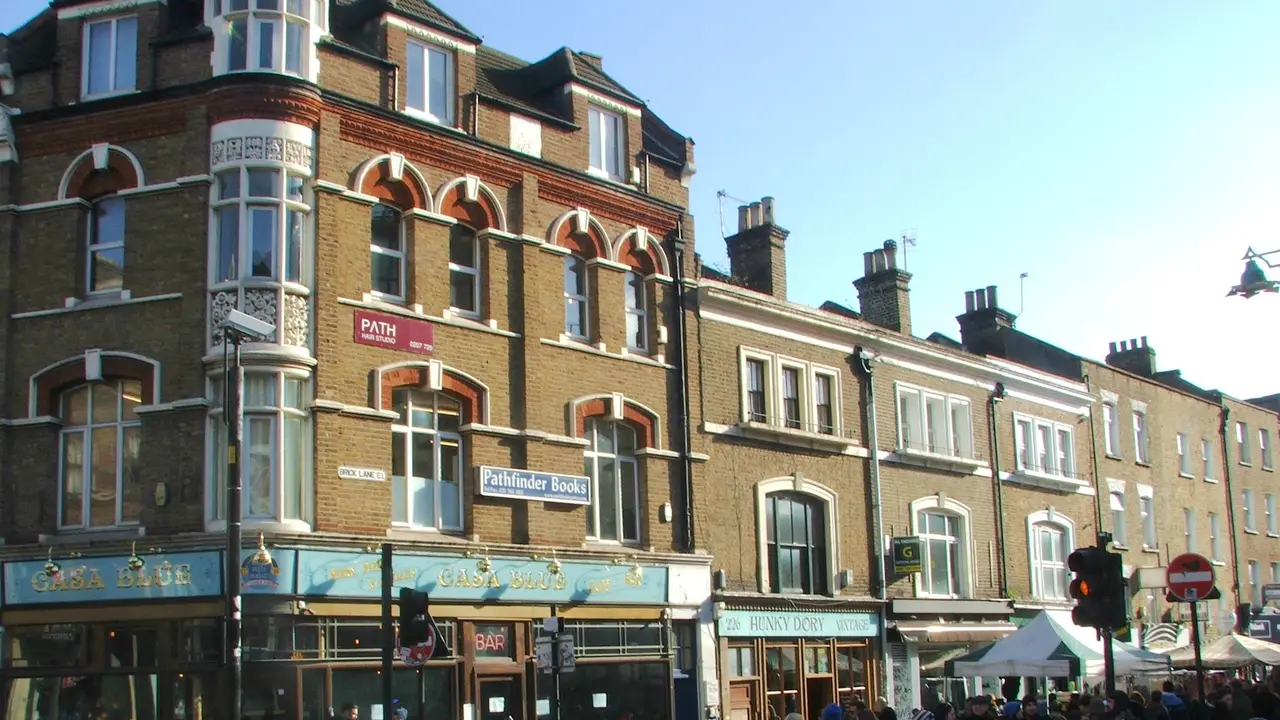 The corner of Brick Lane in Shoreditch, east London, with people on the pavement